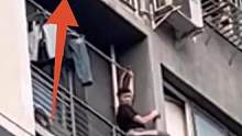 小孩悬空卡在阳台护栏，男子跨窗托举营救。#人间温暖