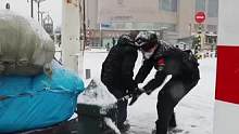 雪天路滑，沉重拖车拉不上去，执勤特警及时伸出援手。“总有一些温暖，让我们心生力量”。