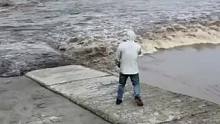 男子站在江边拍涨潮，路人好心提醒！#随拍 #危险