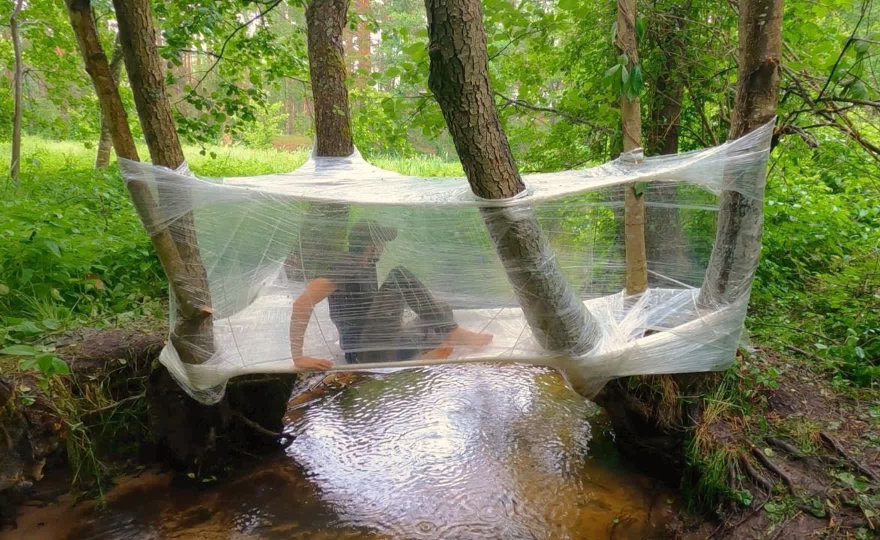 小伙在野外流浪有绝活，用塑料薄膜缠绕出避难所，还能抓鱼烤着吃