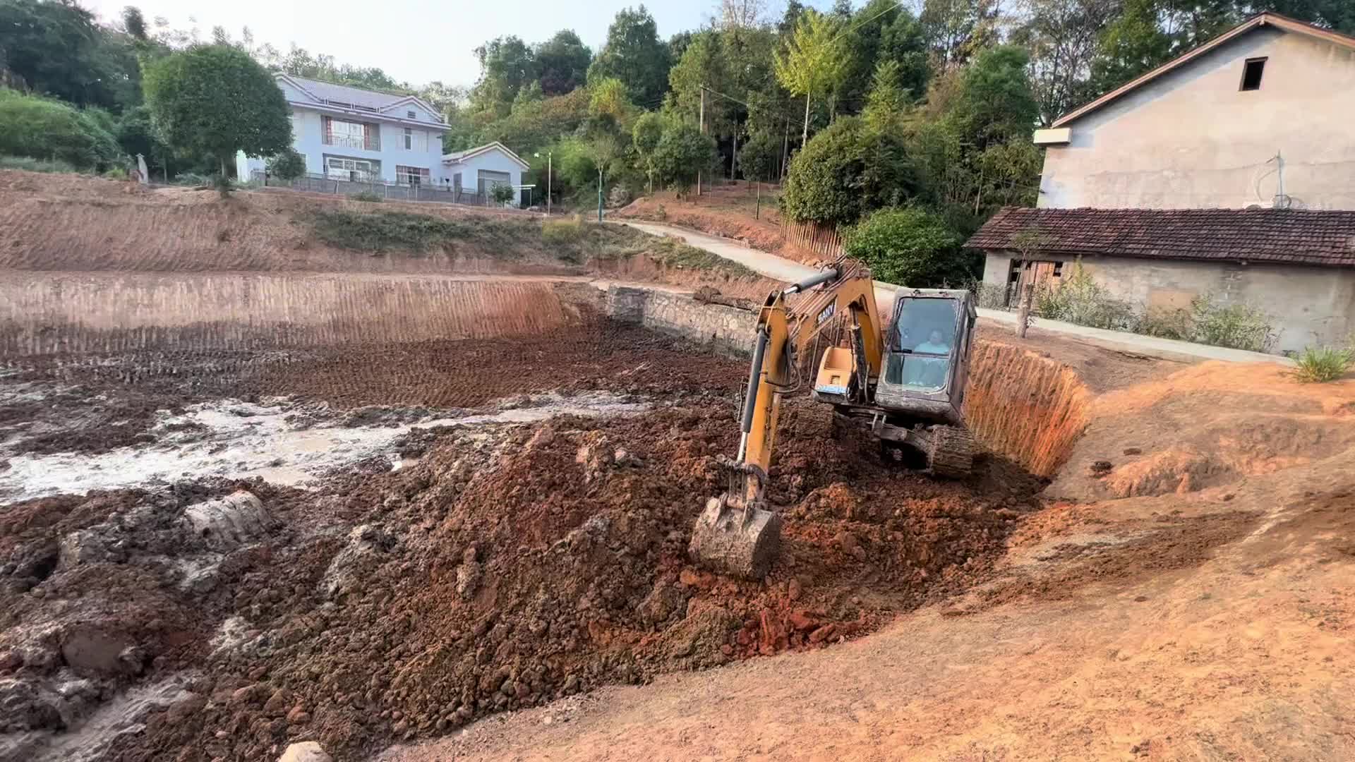 鱼塘中挖一个眼，清理泥巴，修一下坡。老板看着笑呵呵