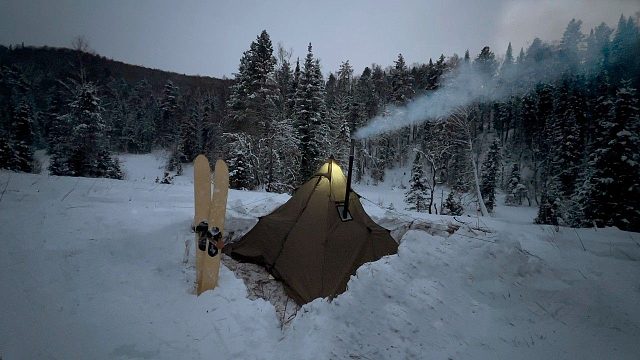 寒冷不惧怕危险，一个人在野生森林中，在深雪中用热帐篷露营