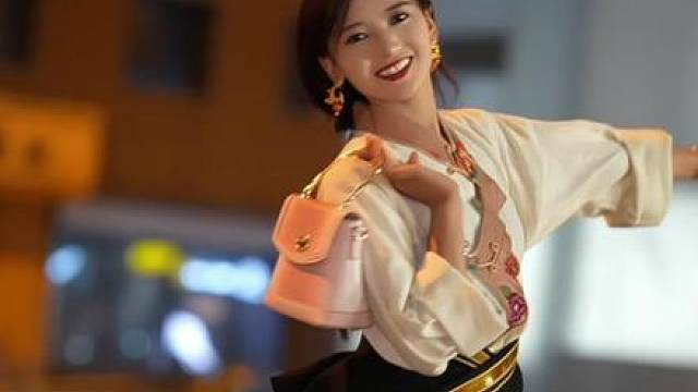 当一个藏族女孩身穿藏服走在城市的街头