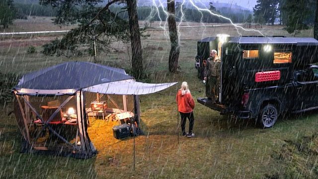 夫妻二人驾驶房车，带着奢华帐篷装备到野外露营，下着大雨窝里面睡觉好享受