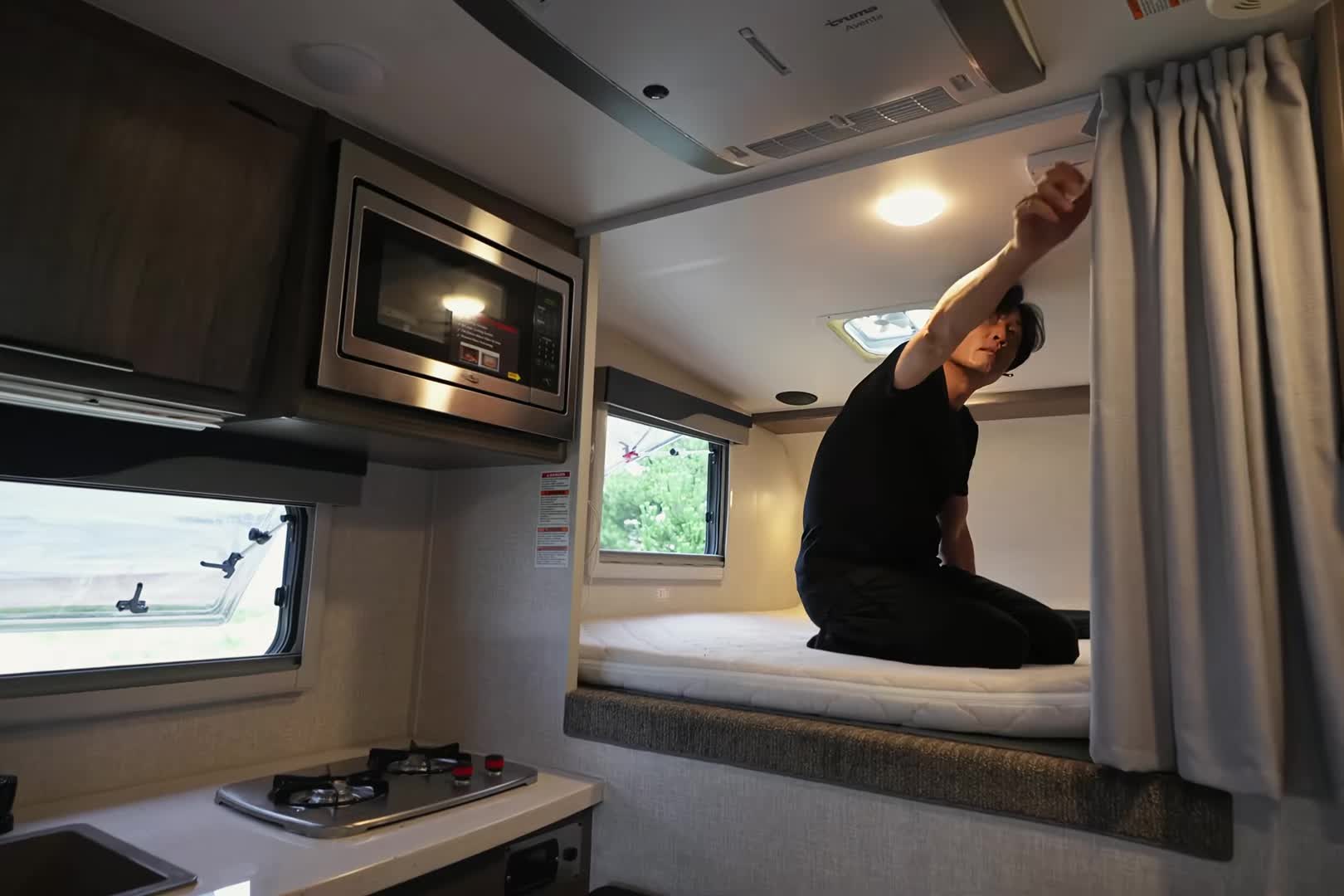 男人驾驶着房车到海边沙滩，暴雨中露营生活，享受户外生活