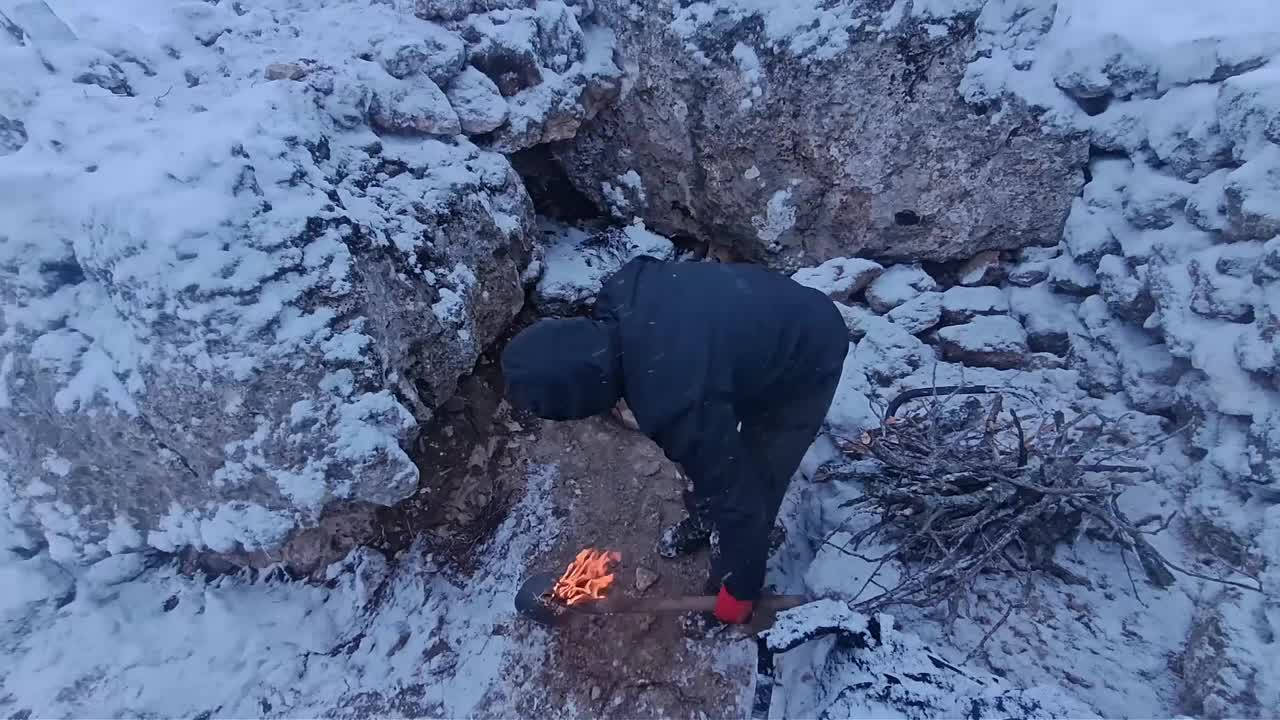 大雪纷飞的野外，男人给自己搭建了舒适的荒野小屋
