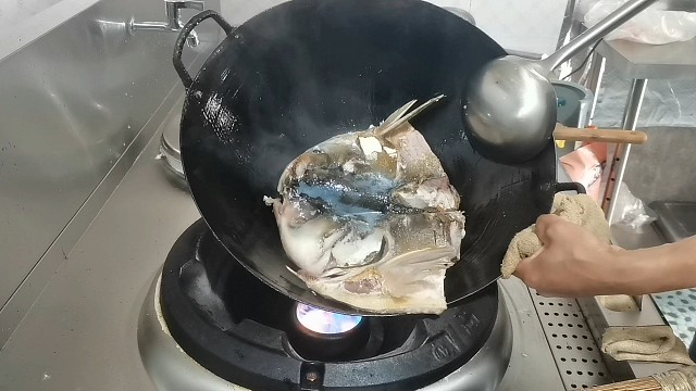 客人对厨师做的鱼头不满意，亲自上灶示范，一出手把老板看愣了