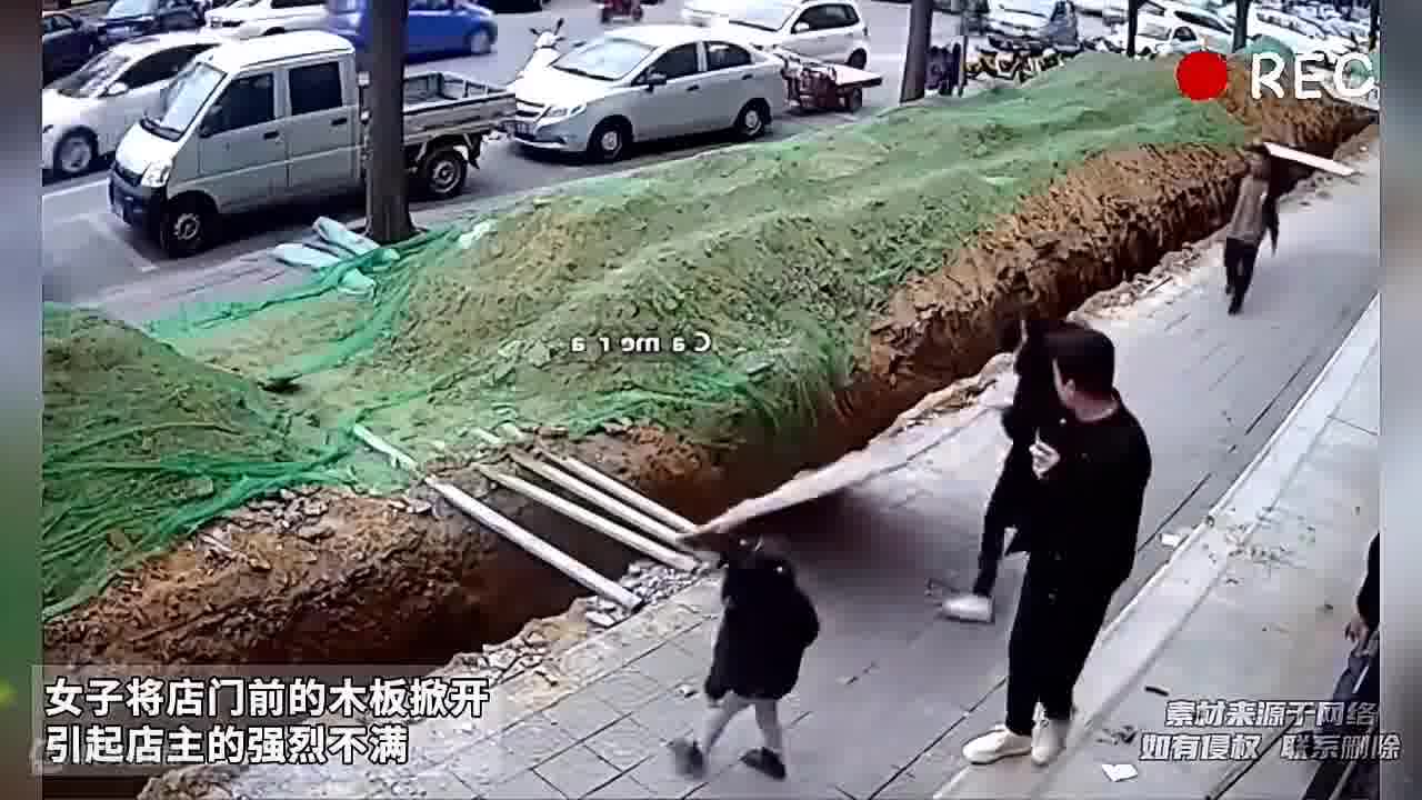 女子将店门前的木板掀开，引起店主的强烈不满