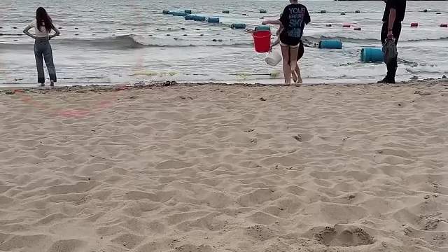 联合双胞胎美女给妹妹在海边制作一个水箱陷阱