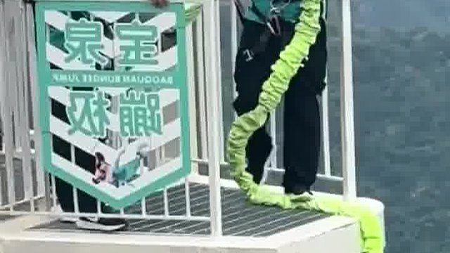 小伙子夏天蹦极故意迈脚假装跳下，吓得工作人员立马把他拉回来
