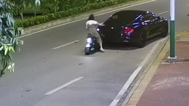 女子骑车追路边违停的新宾利后离开