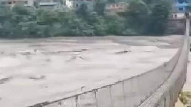山洪暴发河水暴涨，尼泊尔男子涉险在吊桥上狂奔，只因对岸是他全家老小