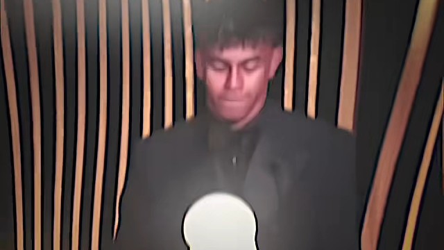 男子手持发光奖杯，神情专注。#足球