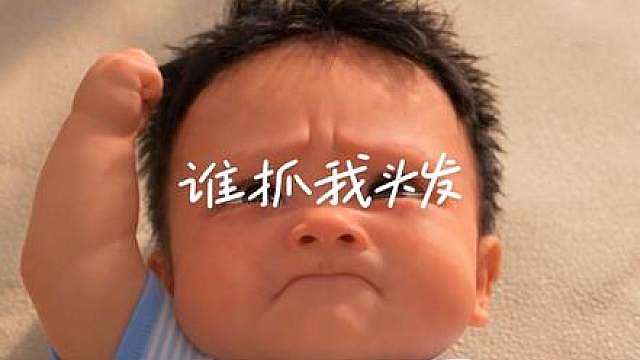 人类幼崽逮着自己头发使劲薅，疼得皱起小脸大哭也不撒手，主打一个自己跟自己较劲