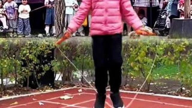 小女孩在花样跳绳，跳出了万马奔腾的状态引众人围观