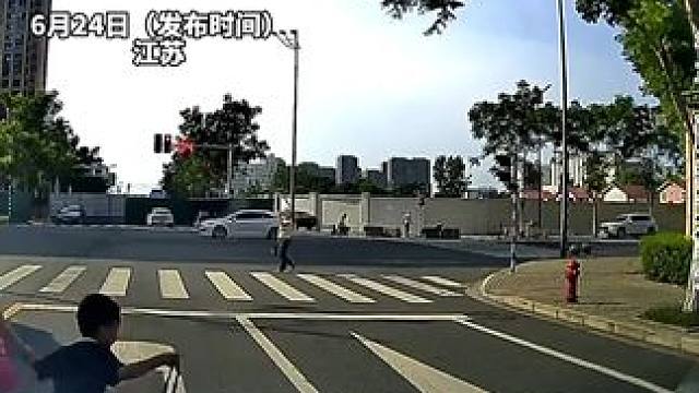大妈带孙子闯红灯，险些被正常行驶的车辆撞到，网友：把马路当自家客厅了？