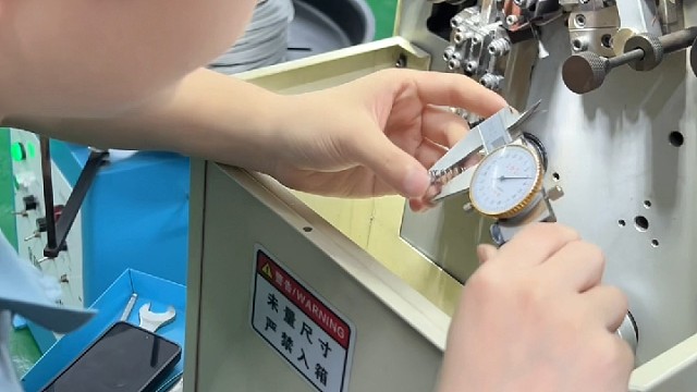 调弹簧的师傅，眼神专注，手上没半分含糊