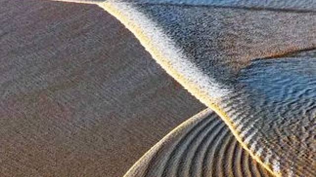 夕阳下的波纹潮和交叉潮，是两种极具诗意与动感的自然奇观，它们在水面、光影与色彩的共舞中呈现出令人心醉