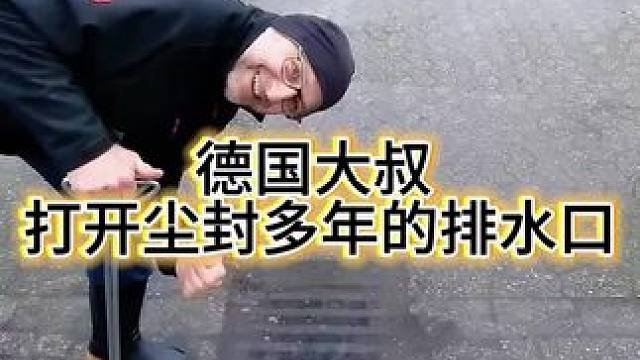 撬开堵塞的排水口 德国大叔在雨天，撬开了被淤泥堵住的排水口