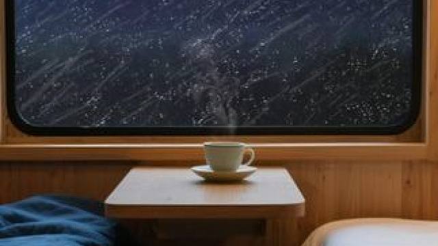 雨夜乘着火车驶向远方，舒适包厢氛围，能听到雨声和铁轨声