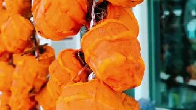 秋风起，柿子红透映窗，如诗如画。 一串串橙黄，是季节的馈赠，也是家的温暖。