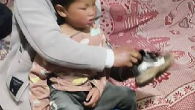孩子的爸帮小双穿鞋。