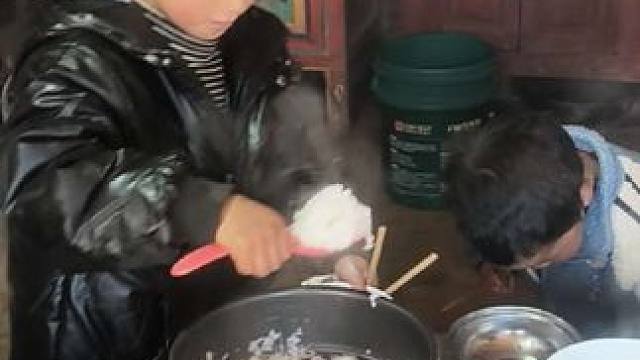 老大给弟弟妹妹添饭。