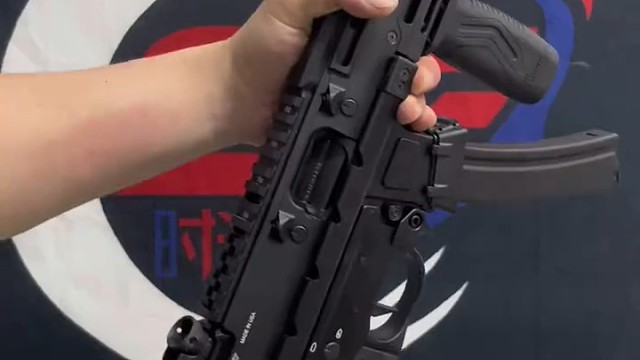 男人手中的玩具枪，闪耀着金属光泽，仿佛带着不羁的梦想，是他闲暇时释放激情的小小寄托。