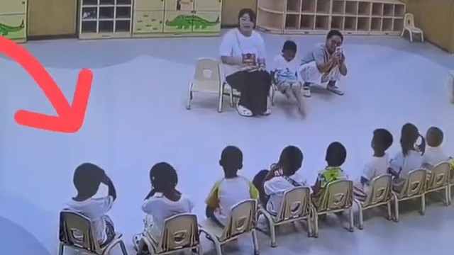 老师蹲在地上给孩子们拍视频，男孩见状主动搬椅子给老师