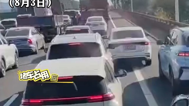 高速出现长时间拥堵不少车主占用应急车道。一轿车刻意压线行驶挡住应急车道。车辆后车女司机穿着高跟鞋两次