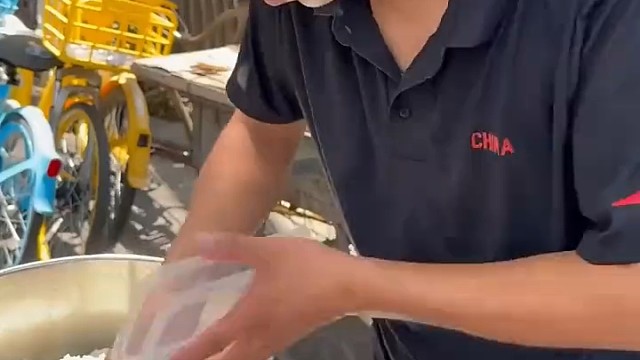 男子在医院门口为病人做免费的“爱心餐”，病人家属给男子送来西瓜表示感谢