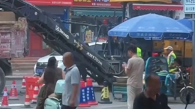 高温天女孩一个人坐在路边等修路的爸爸，店家看到后主动邀请女孩进屋吹空调休息1