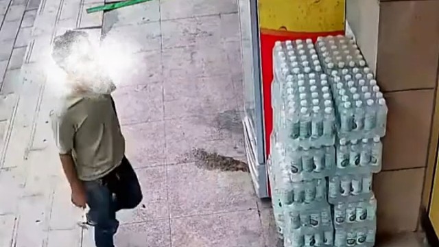 爱心冰柜旁边堆放着矿泉水，男子上前搬走11箱