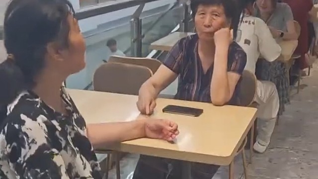 女子在饭店买完吃的 没有地方坐 座位全被乘凉的老年人占了 女子：这家饭店不被她们搞垮算我输1